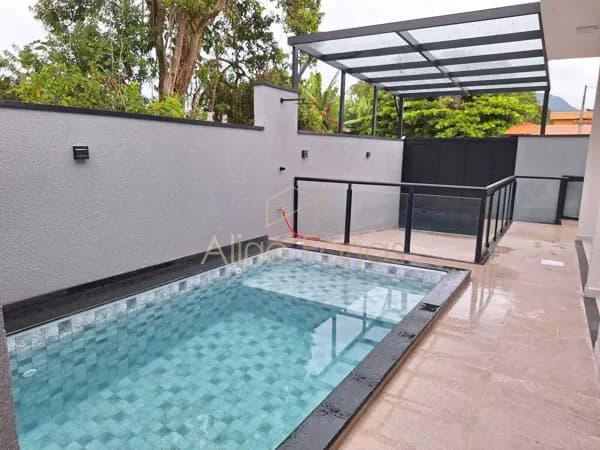 Casa com pé-direito alto, piscina com cascata e acabamento impecável à venda em Peruíbe