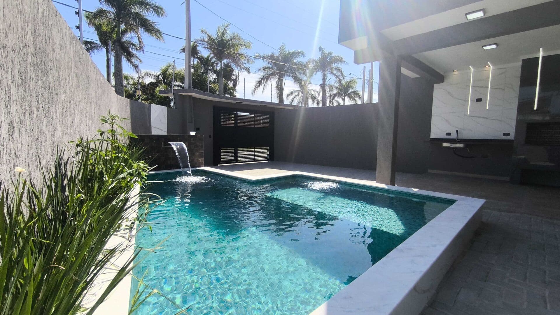 Casa de esquina com piscina a 300 metros até a praia à venda em Itanhaém/SP.