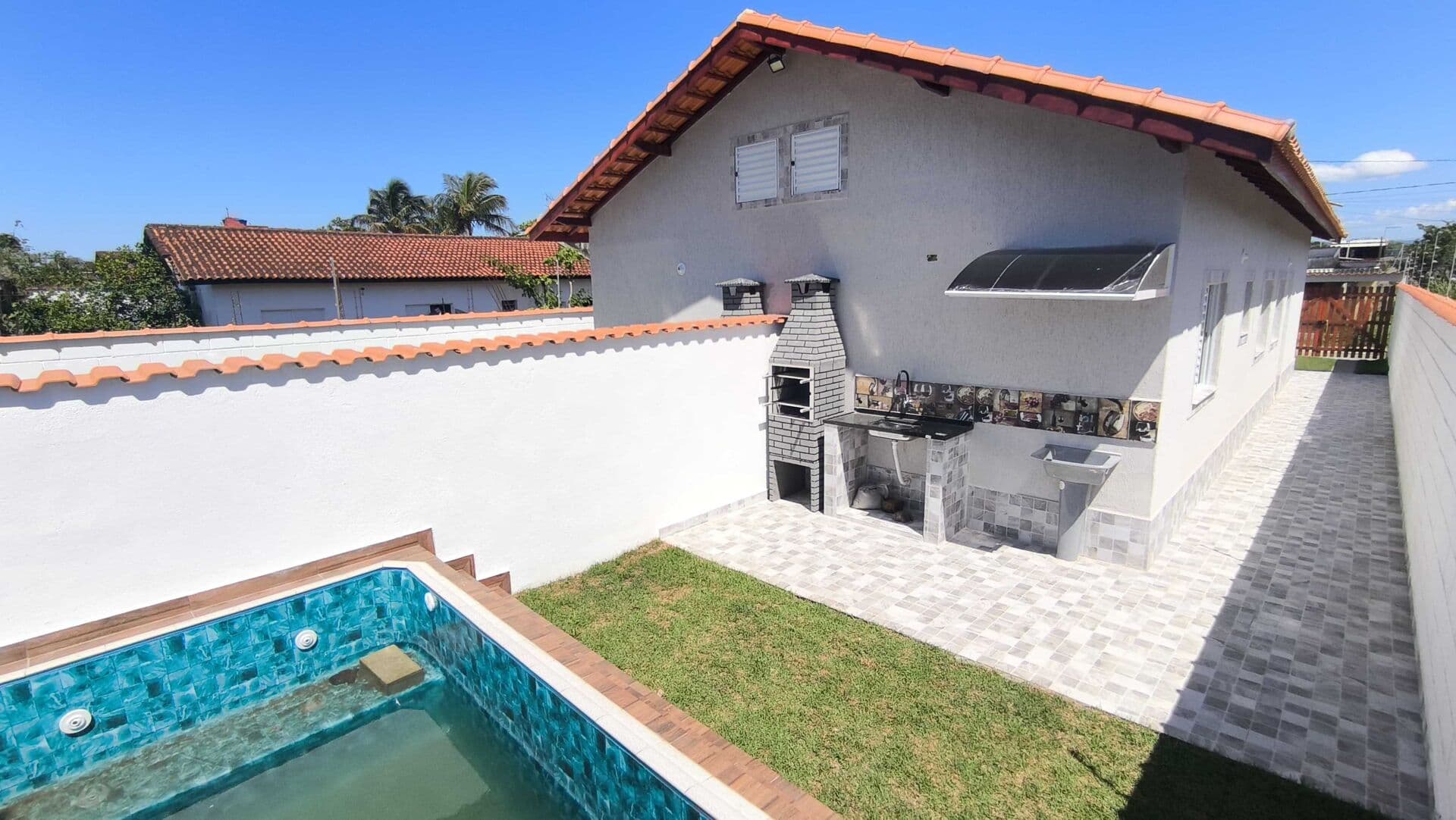 Casa com piscina em bairro residencial com comércio próximo à venda em Itanhaém/SP.