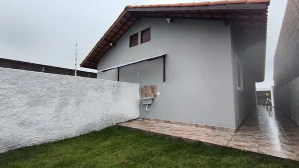 Casa lado praia com quintal gramado nos fundos à venda em Itanhaém/SP.