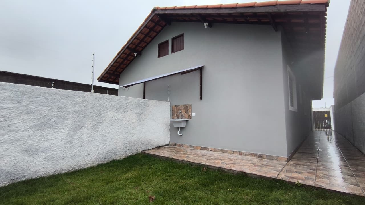 Casa lado praia com quintal gramado nos fundos à venda em Itanhaém/SP.