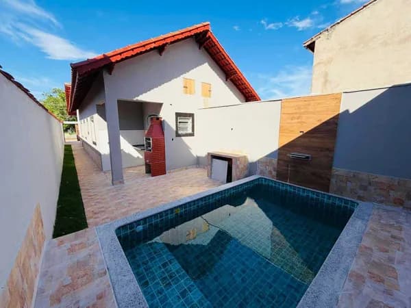 Casa em bairro residencial com piscina à 650 metros do mar à venda em Itanhaém/SP.