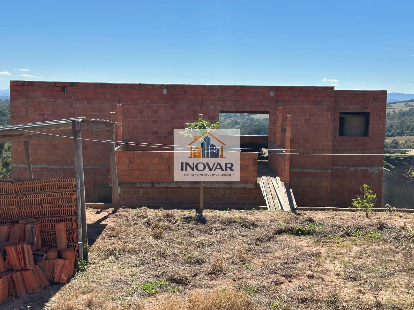 Terreno com duas casas em construção à venda