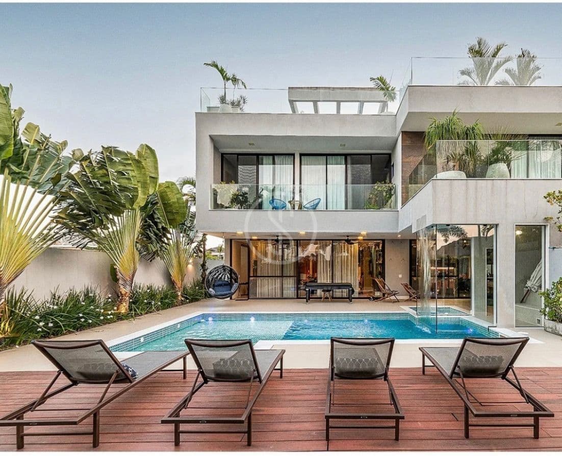 Casa triplex com projeto contemporâneo, vista para lagoa e porteira fechada no condomínio Alphaville, Barra da Tijuca - RJ