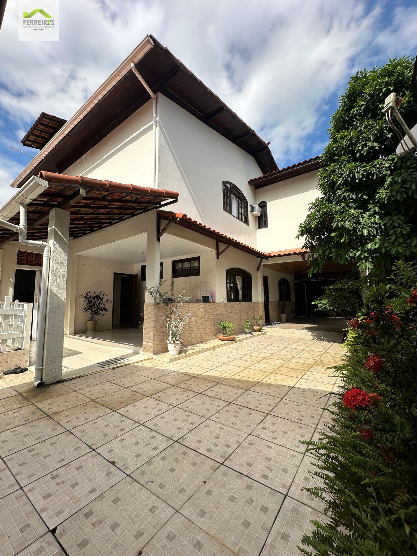 Casa com fachada imponente colonial, possuindo 2 fênix na calçada.